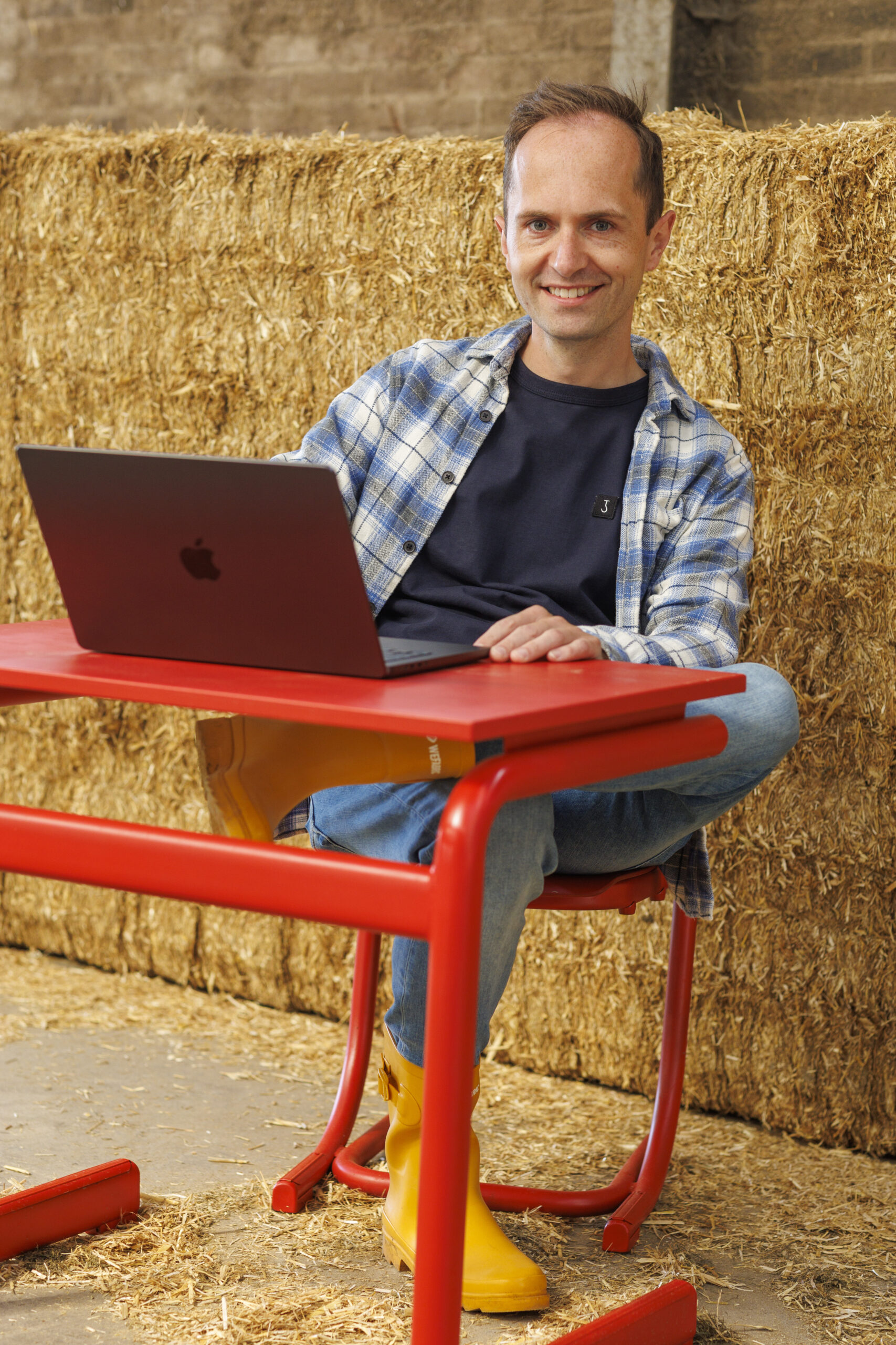 Leo achter laptop in stal