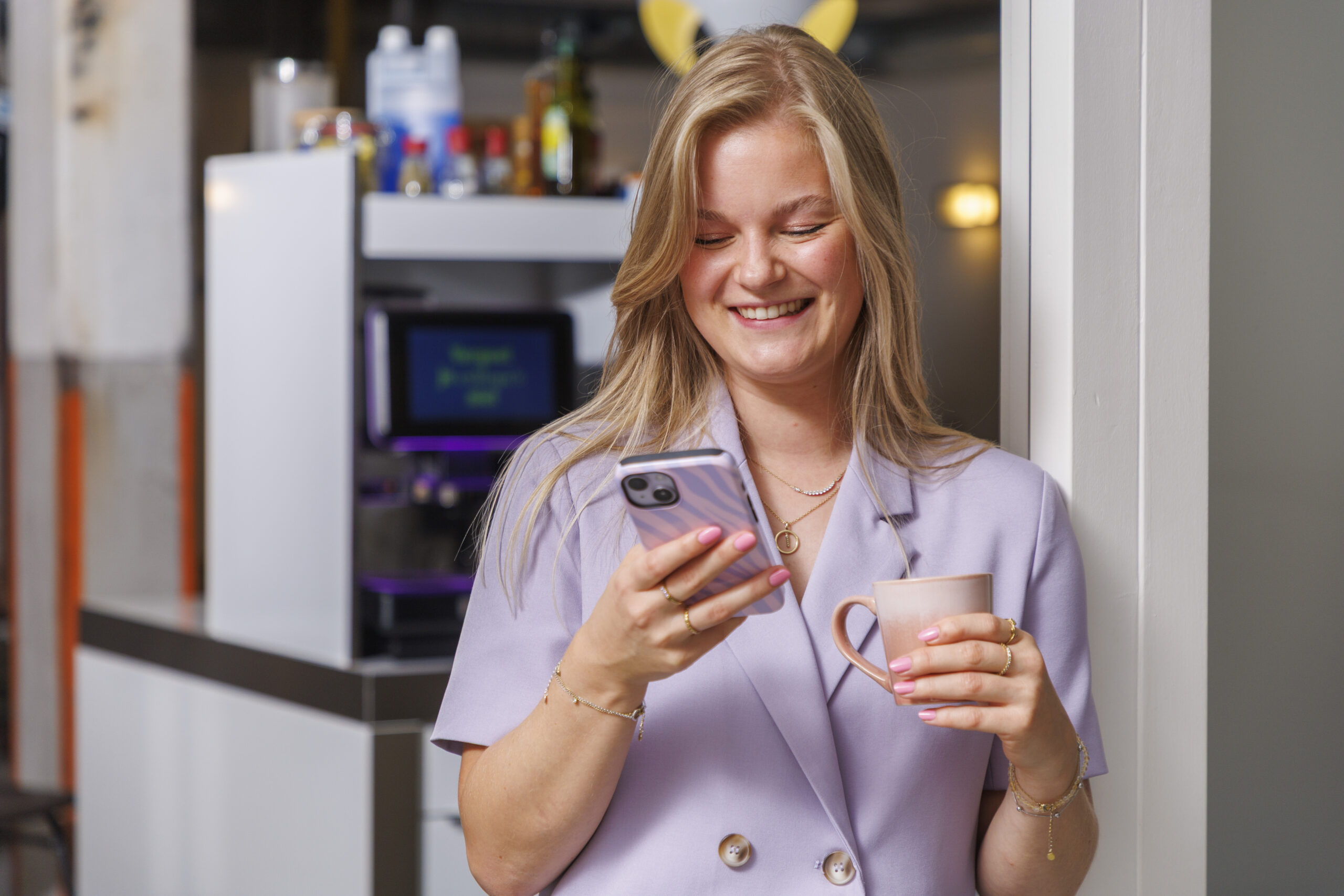 Calla kijkend op telefoon met koffie